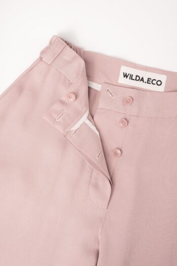 WILDA.ECO handcrafted rose pink trousers showcasing embroidered brand logo label